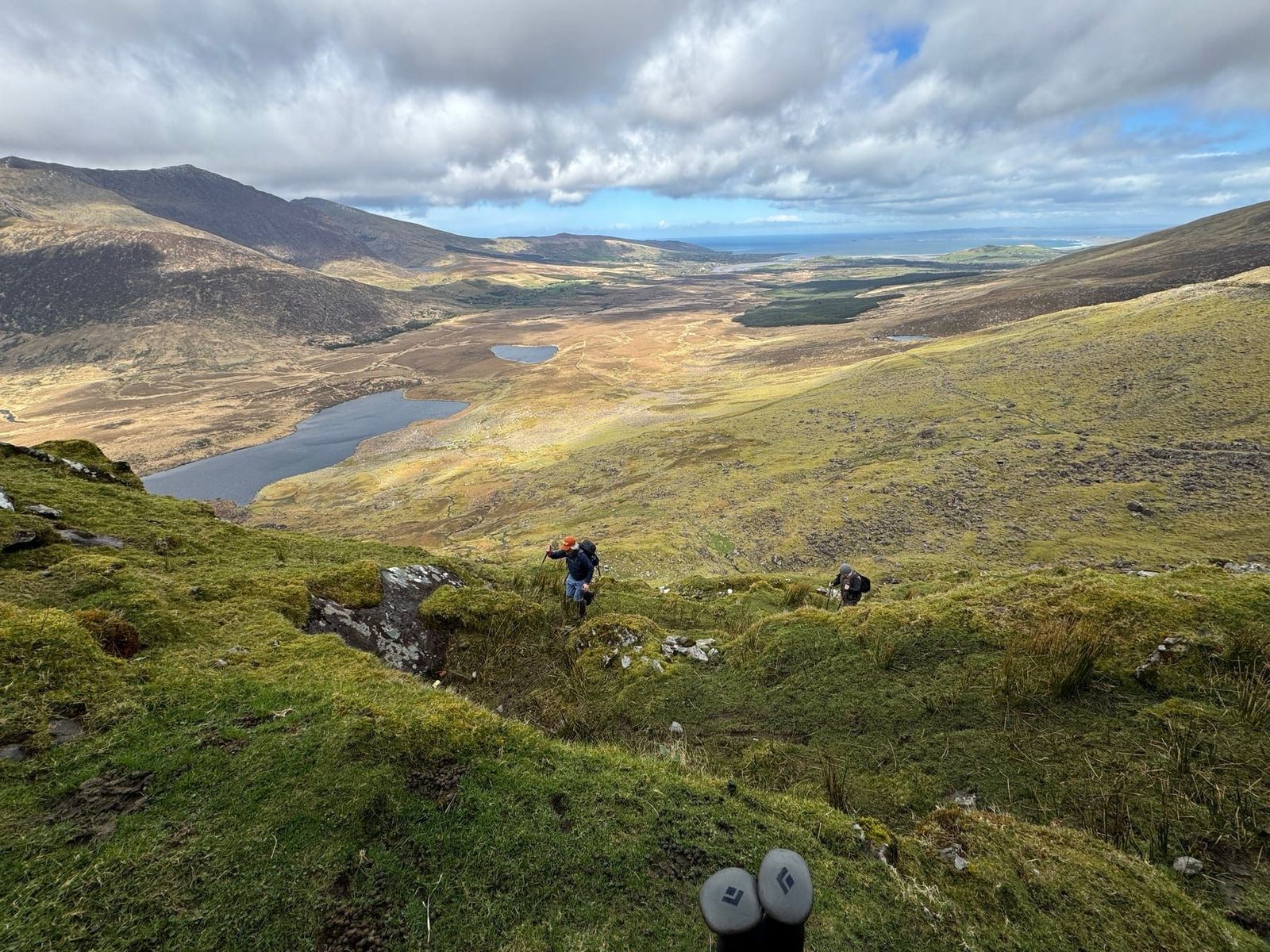Walkers descending into a broad mountain valley