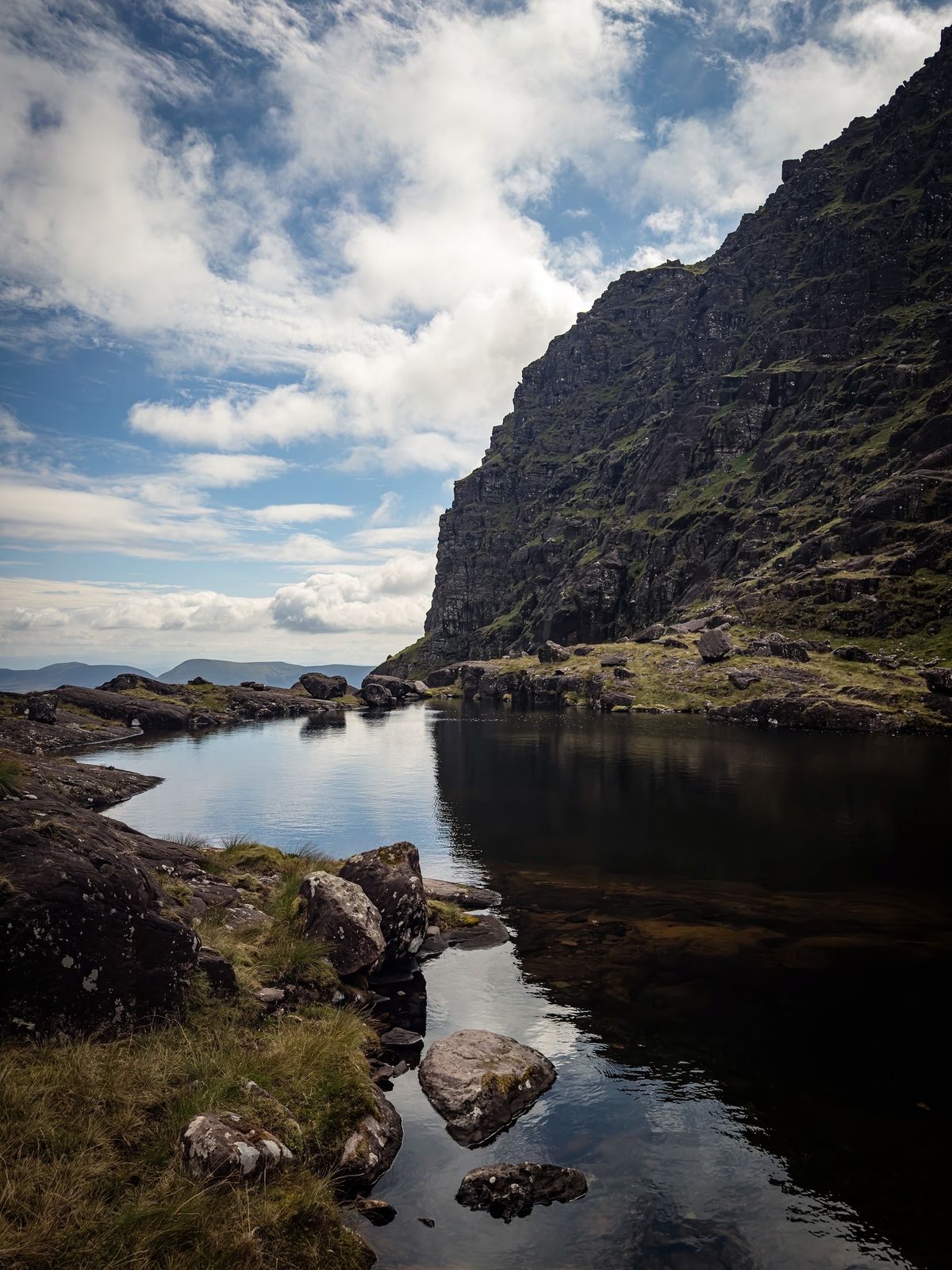 A still mountain lake beneath the dark cliffs of the corrie