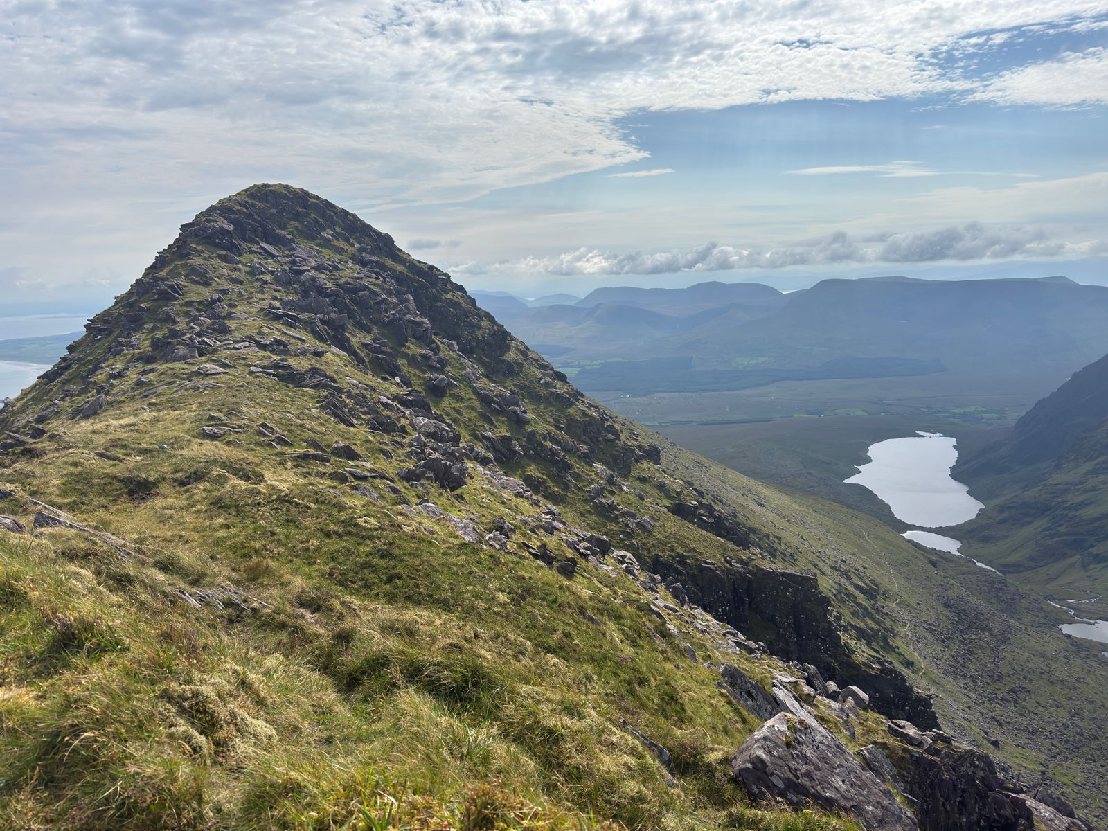 The steep rocky profile of Binn na bPórt above a distant lake