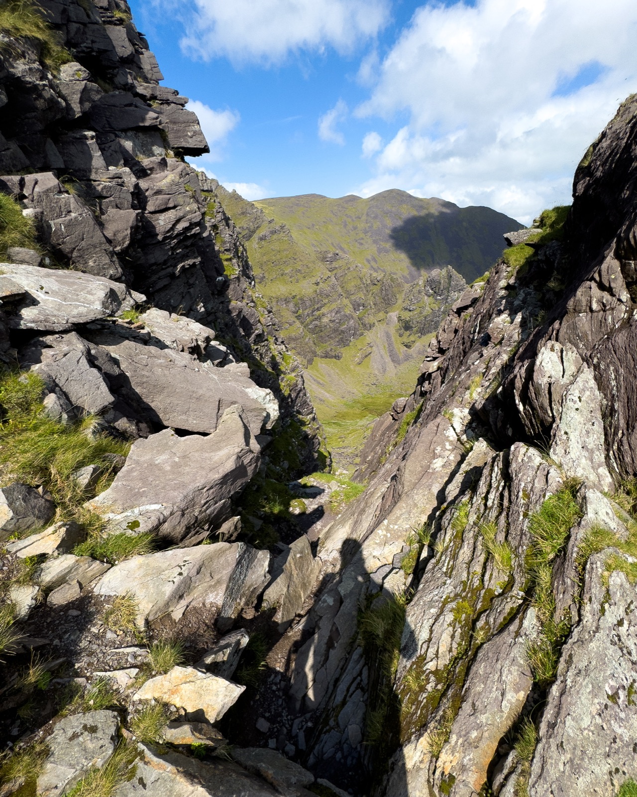 Looking through a steep rocky gully towards the mountain ridge