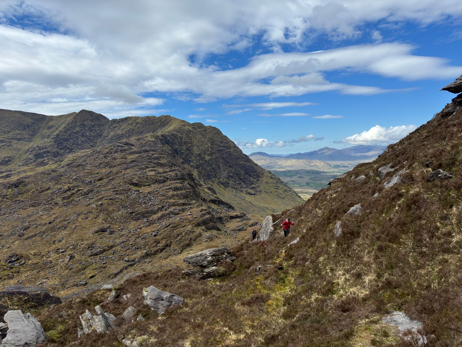 A rugged mountain ridge and distant lowlands seen from the ascent