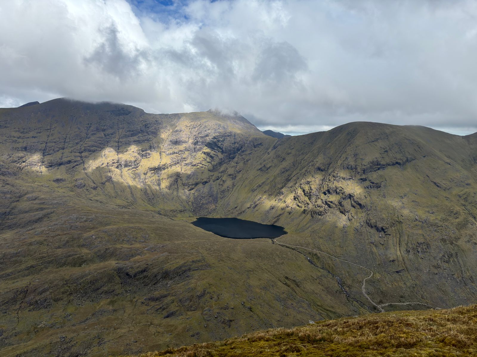 A dark corrie lough beneath broad mountain walls