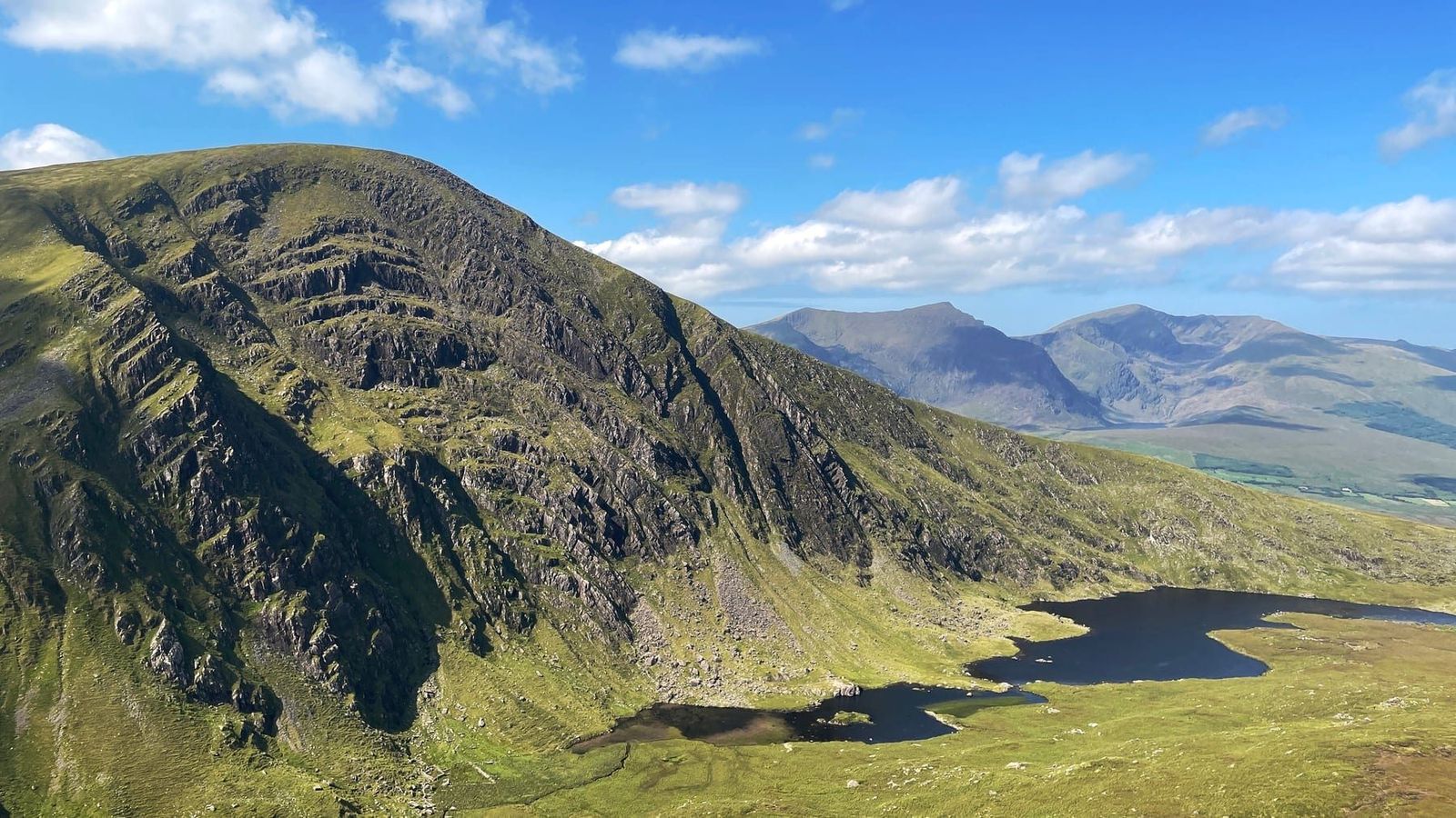 A bright summer view across the Com an Áir corrie, lakes and surrounding mountains