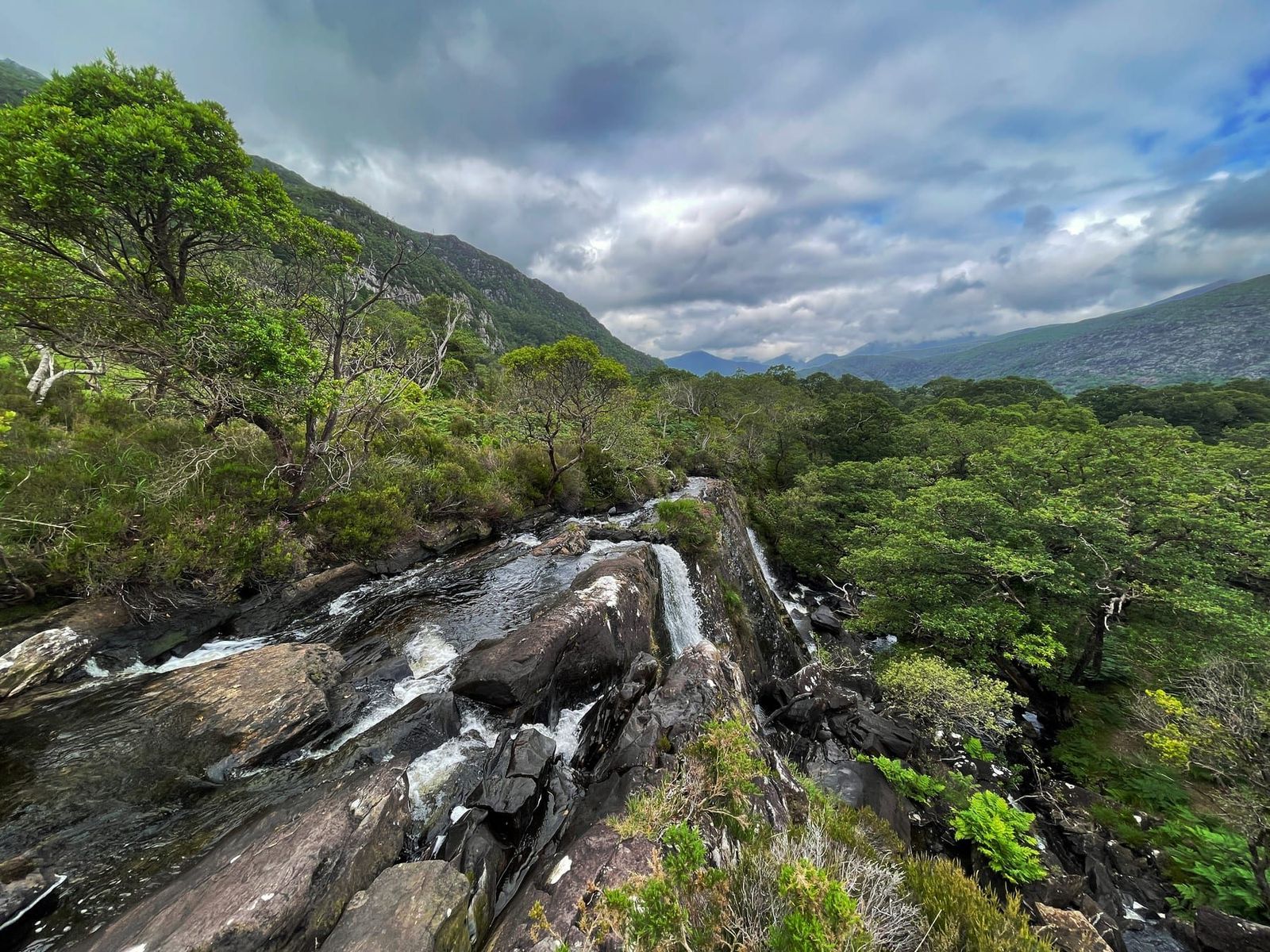 Fast water flowing over rock with the mountain valley beyond