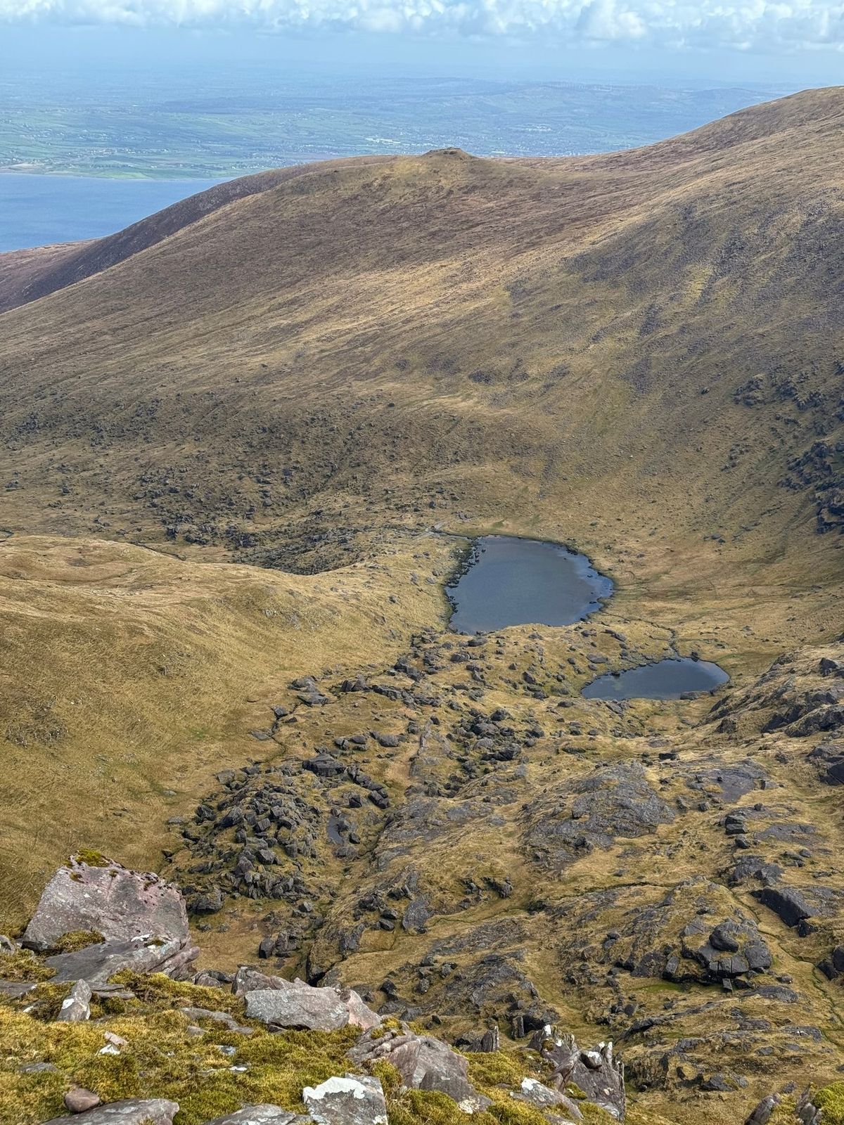 Two small mountain loughs lying below steep brown corrie slopes