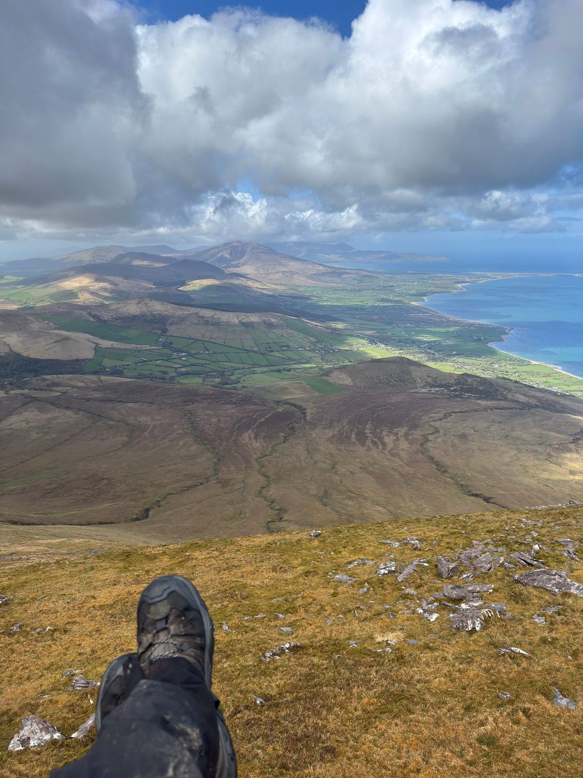 A broad view from the high ground across fields and coast towards Tralee Bay