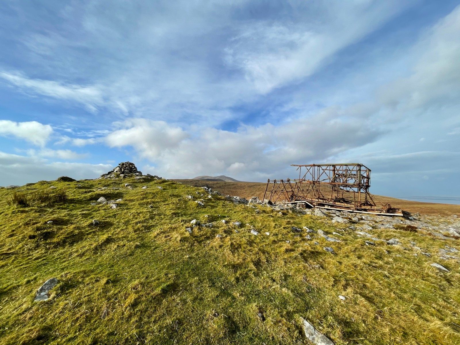 The Iron Man structure and a stone cairn on open mountain ground