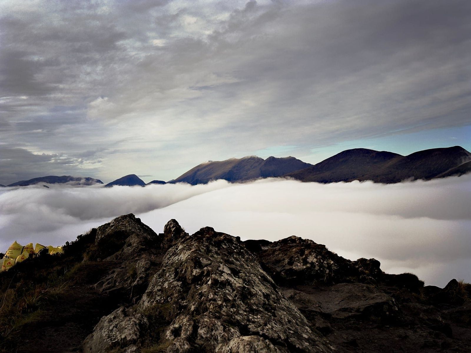 Dark mountain ridges floating above a broad cloud inversion
